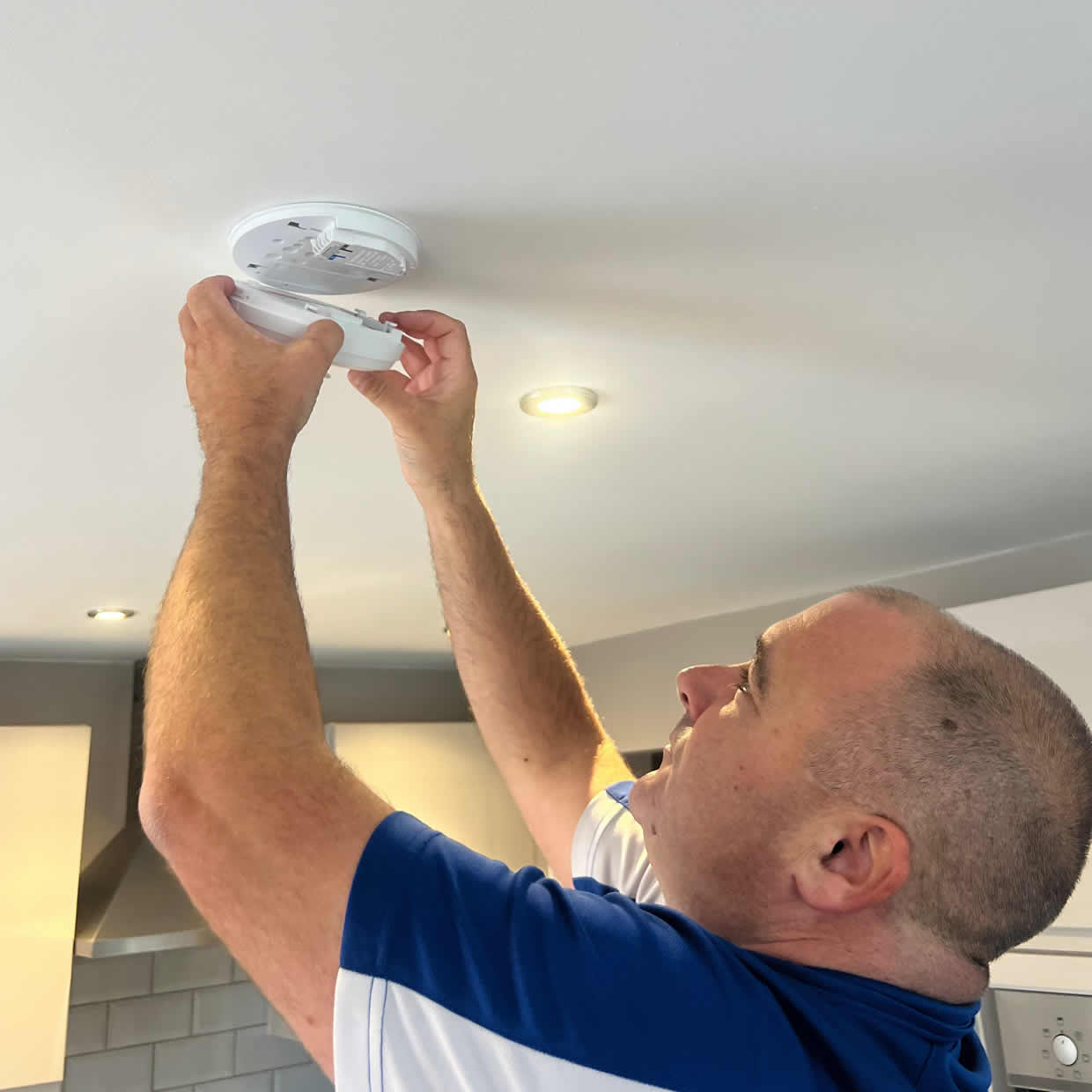 Smoke alarm being installed on a ceiling in Sutton